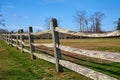 An old split-rail fence with green lichen borders a field.