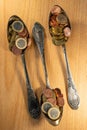 Old spoons and euro and eurocent coins lie on the surface of a wooden table Royalty Free Stock Photo