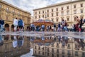 Old square in Florence with carousel and people and tourists haveing fun reflections in puddle