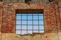 Old window, looking on the blue sky, barred and on red brick wall of old building. Royalty Free Stock Photo