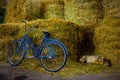 The old stable in the village. A stack of hay bales for feeding horses. Dozing dog. bike. Country side village rural scene Royalty Free Stock Photo