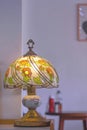 The Old Stained Glass Tiffany Table Lamp with blurred background of Interior white wall of Vintage Restaurant in Vertical frame
