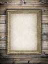 Old stained paper sheet in picture frame on wooden background Royalty Free Stock Photo