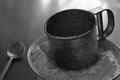 Old stainless steel cup flour sifter lies in a white enamel bowl on an old scratched table Royalty Free Stock Photo