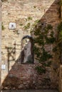 Old statue of madonna with child in wall on Fontegiusta street in Siena. Italy