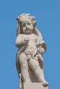 Old statue of a small child in the historical downtown of Dresden, Germany, at blue sky background Royalty Free Stock Photo