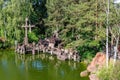 an old steam engine crossing a small wooden bridge over a pond