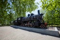 An old steam locomotive of black color stands on a pedestal Royalty Free Stock Photo