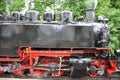 Old red and black steam locomotive engine with steam