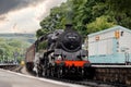 Old steam train in train station with chimney working to carry passengers