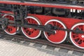 Old steam train wheels approaching, close-up. Black and red wheels. Rails and sleeper Royalty Free Stock Photo