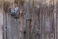 Old steel house number plate 163 on a wood background