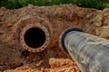 An old steel water pipe with a welded flange lies next to a new plastic pipe installed to connect the water supply Royalty Free Stock Photo