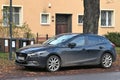 Old but still elegant dark blue Mazda 3 hatchback second generation five door parked