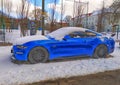 Old blue sport coupe car Ford Mustang parked in snow in Gdansk, March 12th, 2023.