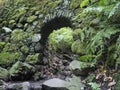 Old stone aqueduct, water duct arc at Cubo de la galga nature park, path in beautiful mysterious Laurel forest Royalty Free Stock Photo