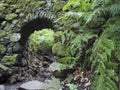 Old stone aqueduct, water duct arc at Cubo de la galga nature park, path in beautiful mysterious Laurel forest