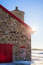 Old Stone Barn with Bright Red Door and Sunflare Royalty Free Stock Photo