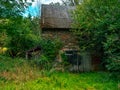 old stone barn with a double door that is overgrown