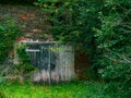 old stone barn with a double door that is overgrown