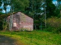 old stone barn with a double door that is overgrown Royalty Free Stock Photo