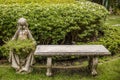 Old stone bench and statue with a vase