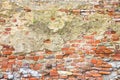 Old stone and brick wall with degraded plaster