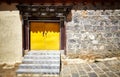 Old stone brick wall with yellow gate, China