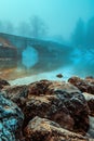 Old stone bridge at Bohinj lake in foggy morning, tranquil scene from Slovenia\'s travel destination in dawn Royalty Free Stock Photo