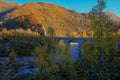 Old stone bridge over the mountain river across autumn forest, hills, and sunset sky. Natural background. Travel, movement, archit Royalty Free Stock Photo