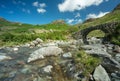 Old stone bridge in remote Lake District nature, with stream and blue skies Royalty Free Stock Photo
