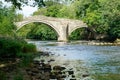 An Old Stone Bridge with Two Arches Crossing a River. Royalty Free Stock Photo