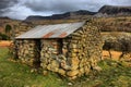 An old stone building with metal roof in front of the cadair idris mountain range in snowdonia Royalty Free Stock Photo