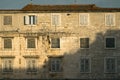 Old stone building with red tile roof and closed weathered wooden shutters Royalty Free Stock Photo