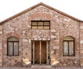 Old stone building with wooden door and two windows with bars. Royalty Free Stock Photo