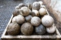 Old stone canon balls stacked in a holding bin in Italy. Royalty Free Stock Photo