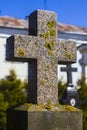 Old stone cross in the old cemetery. Red granite cross with lichen Royalty Free Stock Photo