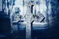 An old stone cross stands in the cemetery in the evening twilight. Religion, sadness and death. Christianity Royalty Free Stock Photo