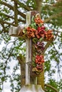 Old stone crucifix adorned with flowers in historical cemetery