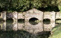 Old stone footbridge reflected in river Royalty Free Stock Photo