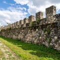 Old Stone Fortification Wall with Grass Field Under Bright Sky at Daytime Royalty Free Stock Photo