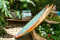 Fountain converted into a flowery pot, with a bench in the background, and surfing boards leaned Royalty Free Stock Photo