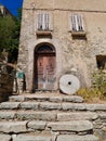 Old stone house with millstone in Lama, a dreamy hilltop town nestled in the mountains. Corsica, France. Royalty Free Stock Photo