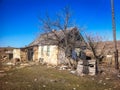 Old stone house under a dry tree Royalty Free Stock Photo