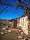 Old stone house under a dry tree Royalty Free Stock Photo