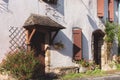 Old stone house in the village. Medieval building with window shutters, door and garden. Backyard of ancient house. Royalty Free Stock Photo