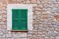 Old stone house wall with closed green wooden window shutters Royalty Free Stock Photo