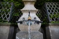 Old stone and metal public drinking water fountain in a city in Switzerland, Europe. Daytime, wide angle, no peop