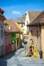 Old stone paved street with tourists from Sighisoara Royalty Free Stock Photo