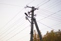 Old stone pillar with lamp and wires on the white sky background Royalty Free Stock Photo